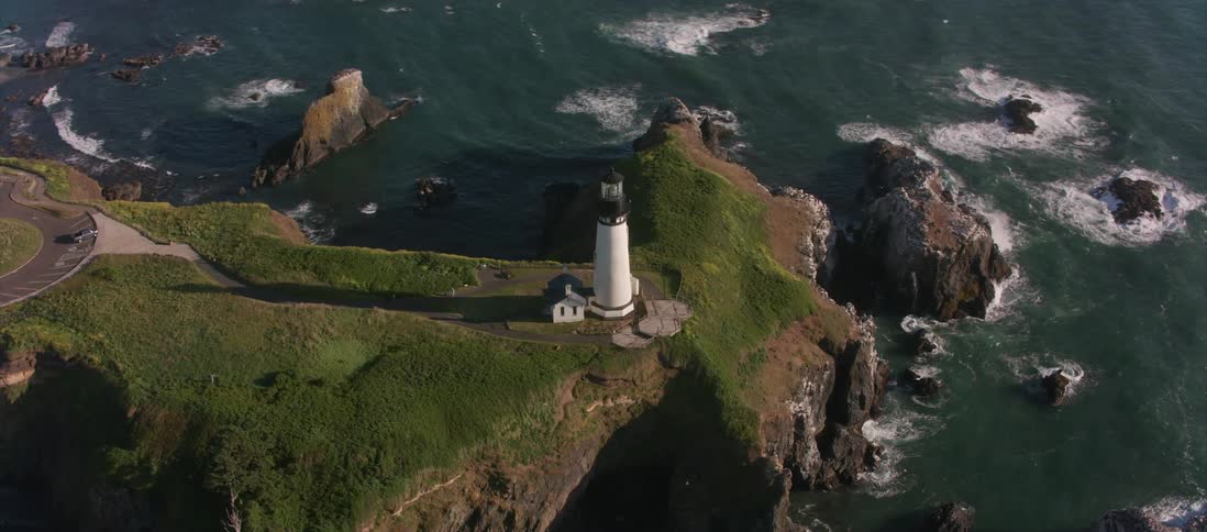 Lighthouse near cliff overlooking rocks