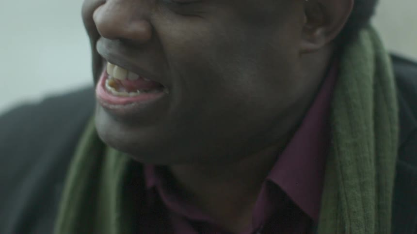 Smiling man turning to look over his right shoulder