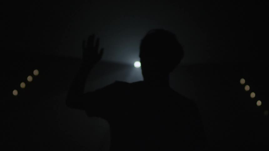 Man raises hand in front of.light