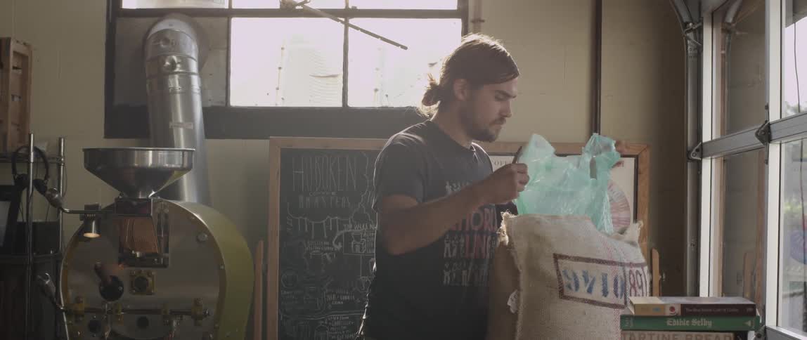 Man opening a large bag in a shop area