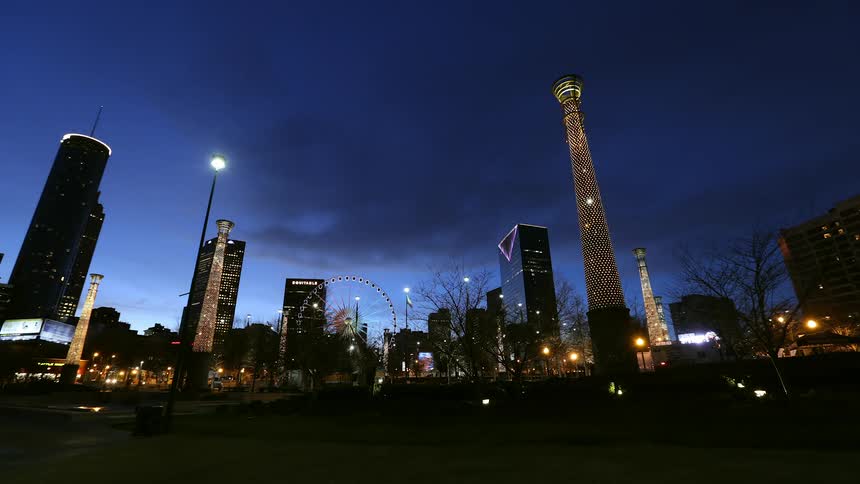Skyscrapers and a ferris wheel light up against the dark night sky
