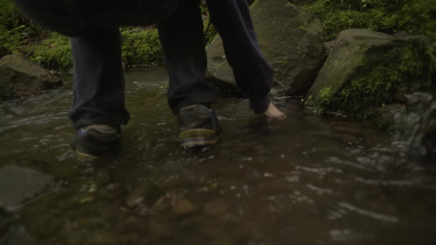 Person walking in a shallow creek in the wilderness