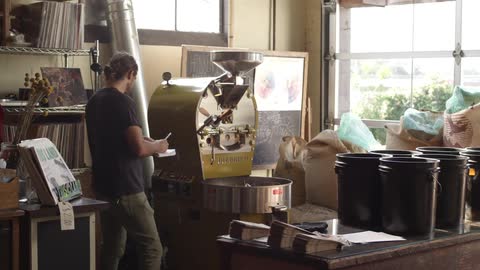 A man examines machinery and takes notes