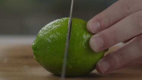 Slicing a lime with a large knife