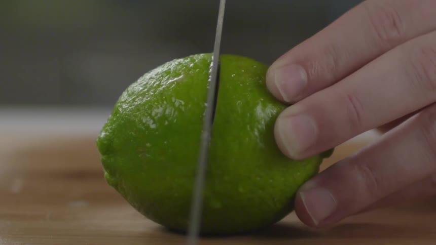 Slicing a lime with a large knife