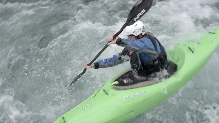 A whitewater kayaker descends a large drop just in front of the camera in this lookdown shot