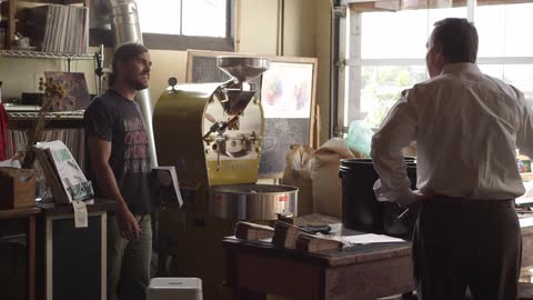 Two men shake hands in a shop