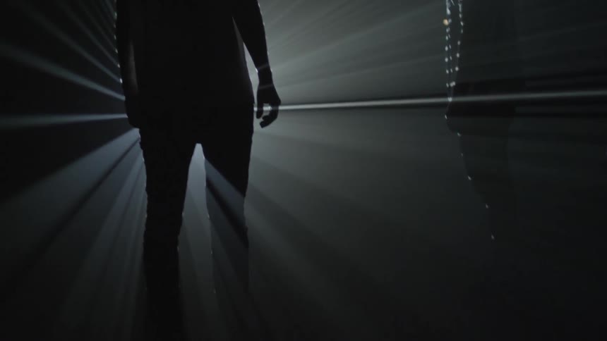 Men stand silhouetted against a bright light