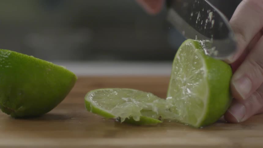 A lime is sliced on a cutting board