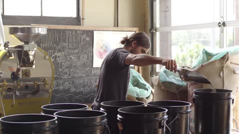 A person filling up black buckets
