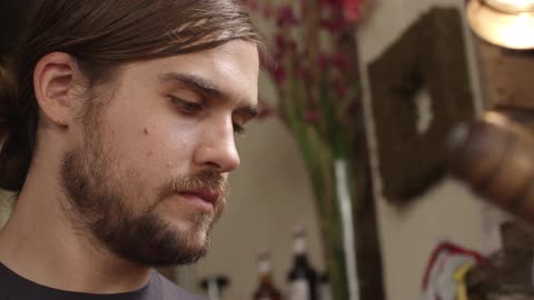 A long-haired brunette man working