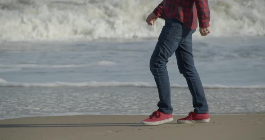 A man walks down a beach