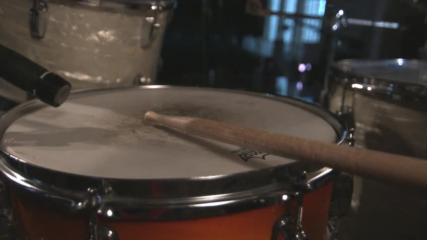 Drumsticks hit a drumhead
