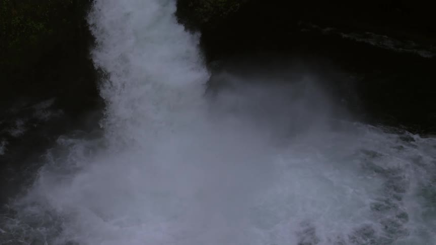 The camera pans right revealing a whitewater kayaker descending a beautiful and picturesque waterfall