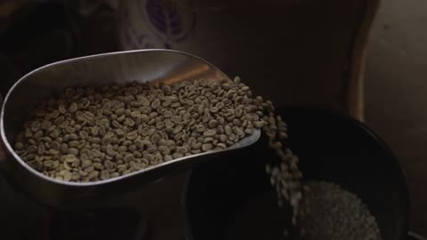 A large scoop pouring beans into a container