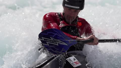 Man with helmet cam uses paddle in the waves