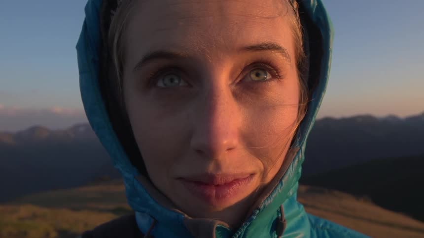 A woman in the mountains smiles