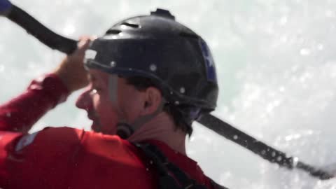 A man paddles in turbulent water