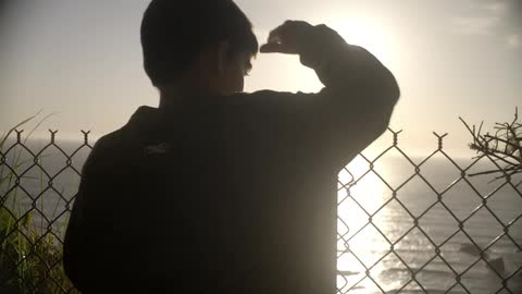 A boy looking over a fence