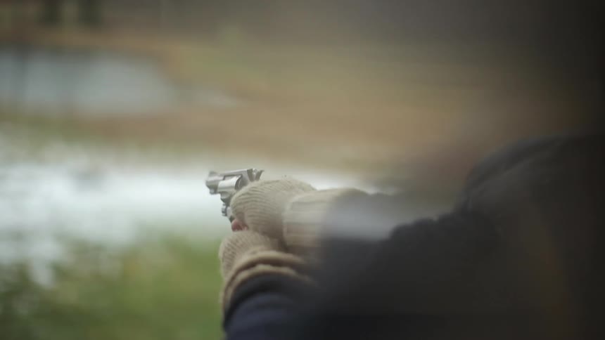 A handgun is fired outdoors