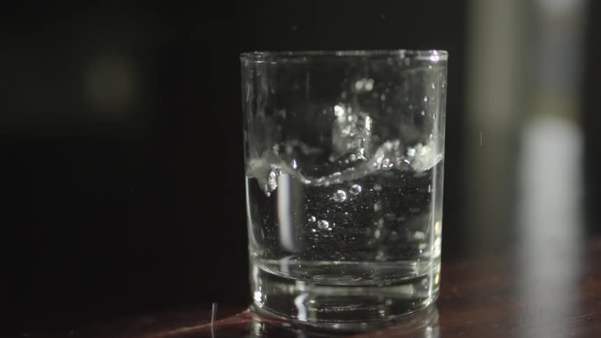 A clear glass of water bouncing
