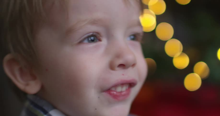 Little boy smiles in front of blurred lights