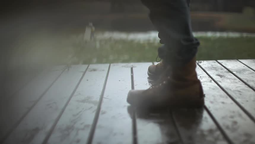 Two people standing on a wet porch