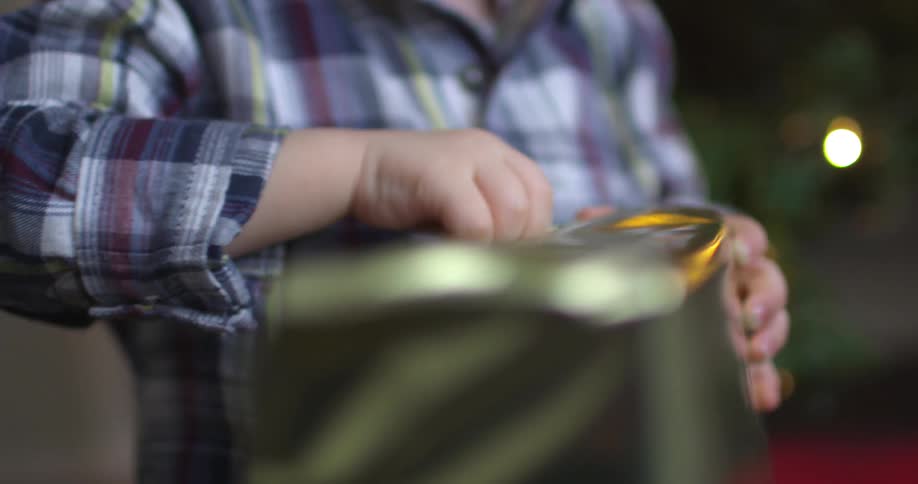 A child rips the wrapping paper off of a present