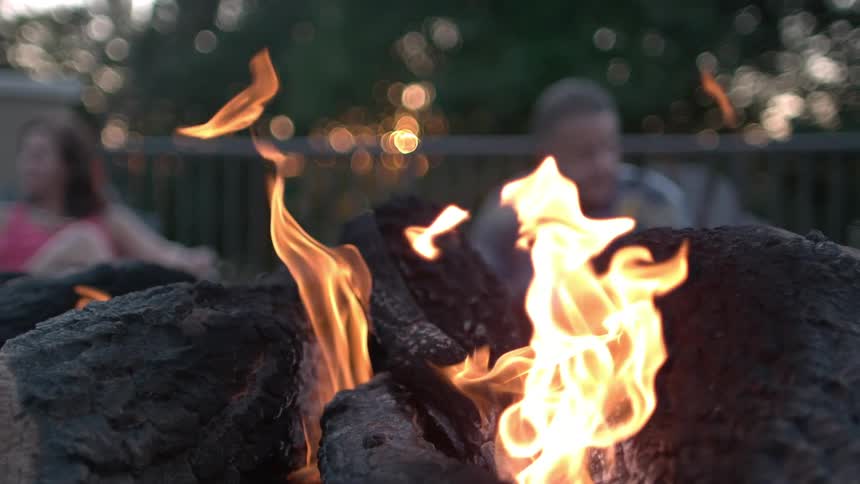 Man and woman in front of a fire at sunset