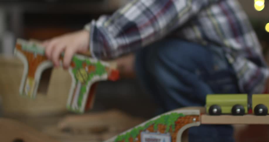 A toddler boy playing with a wooden train set