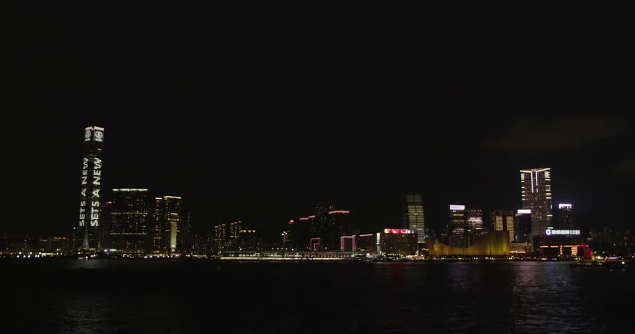 Hong kong city skyline with lights flashing on skyscrapers and buildings along a river