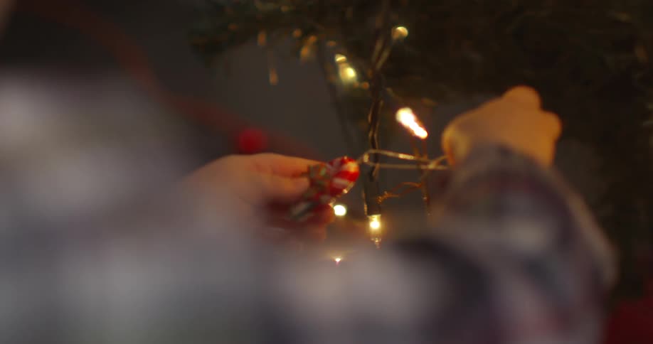 A child trying to hang an ornament on a christmas tree