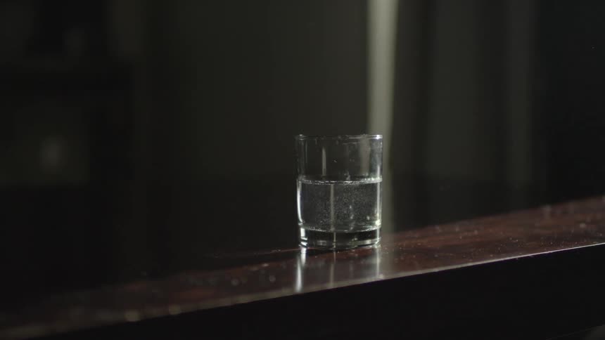 A drink sits on a wood table