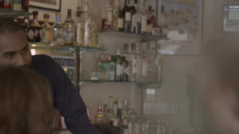 A bartender listens to two people