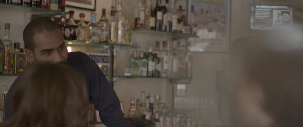 A bartender listens to two people