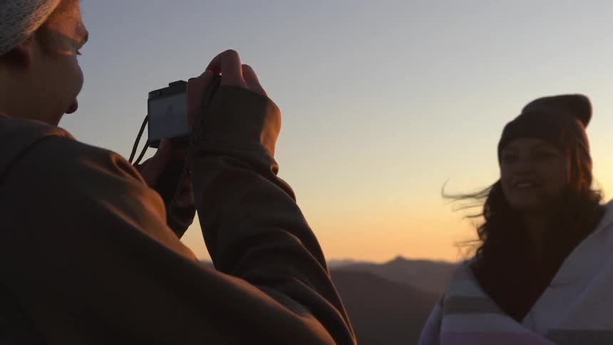 A woman smiles as she is being photographed