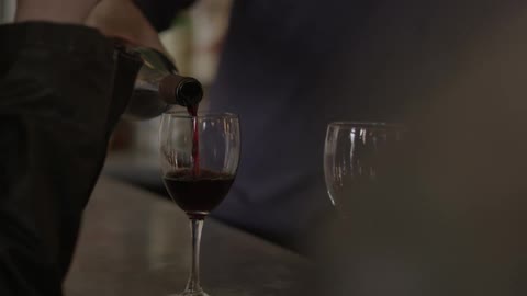 Man pours wine in a glass