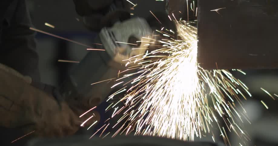 Sparks fly as person sands a metal sheet