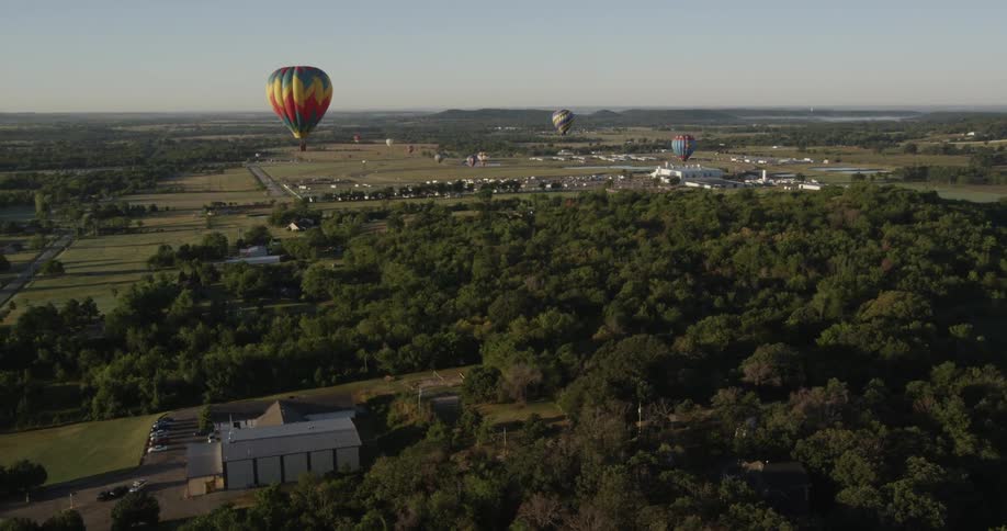 A hot air balloon floats over a small rural town