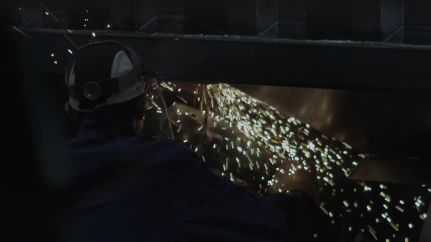 Man in safety gear welds metal