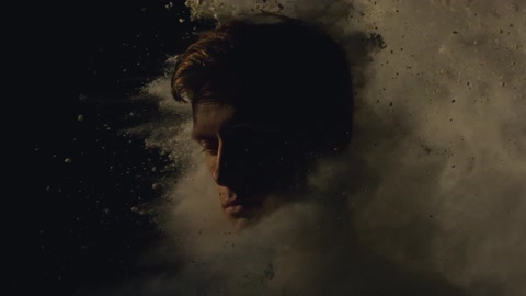 Man's head getting hit from behind by a cloud of white sand or powder