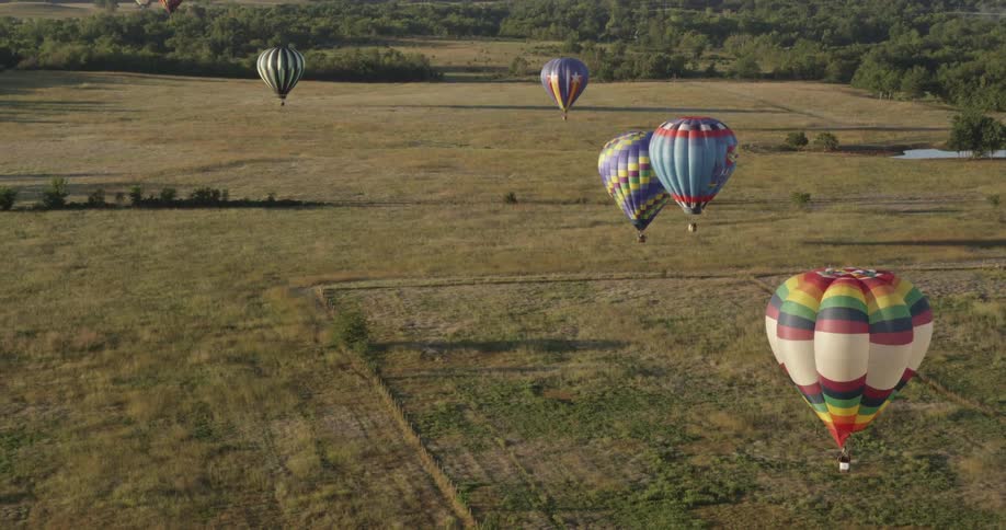 Hot air balloons floating over a field