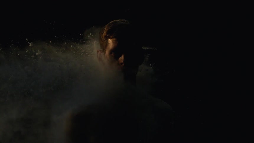 White powder hits a man in a dark room