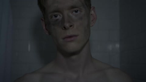 A man with a dirty face standing in a tiled room