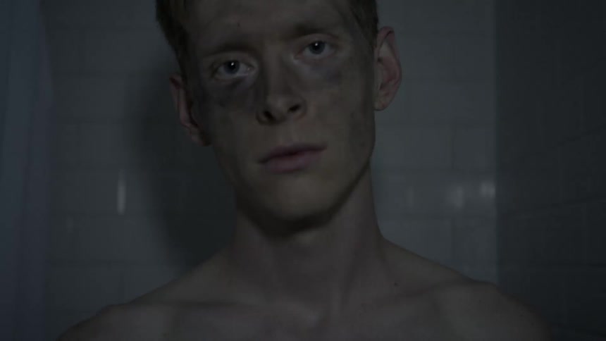 A man with a dirty face standing in a tiled room