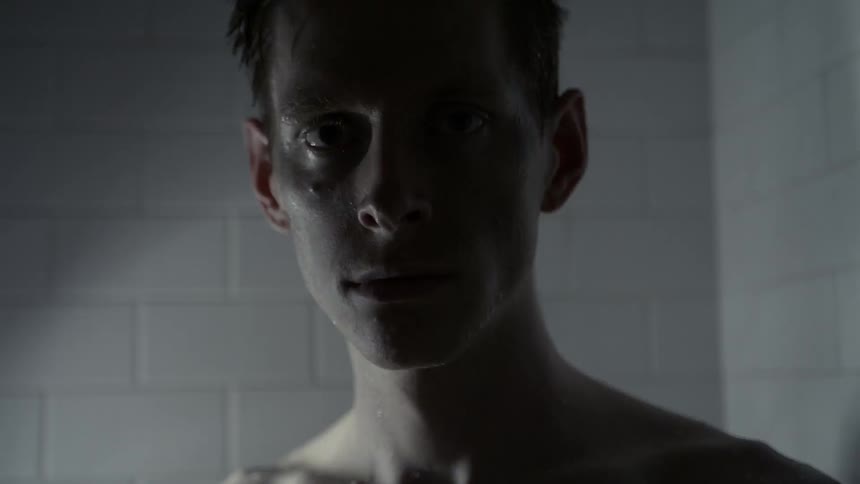 Lights flash showing a man standing before a white brick wall