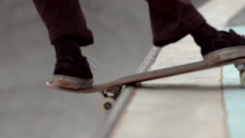 A close shot of a skateboarder reaching the top of a halfpipe, turning and then going back down