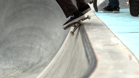 A skateboarder jumps up on a ledge in a skatepark