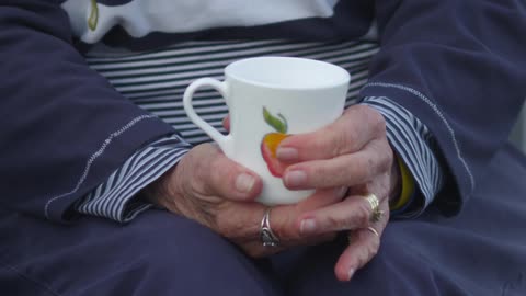 A woman holds and rotates a mug