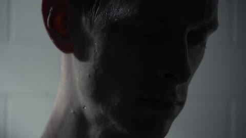A water covered man under a strobe light